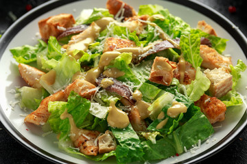 Caesar salad with chicken, anchous fish, croutons, parmesan cheese and greens. healthy food