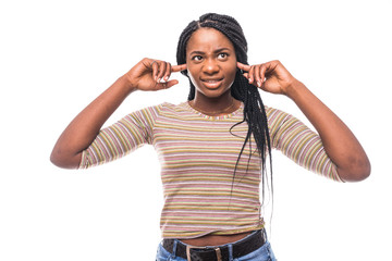 Portrait annoyed, unhappy, stressed african woman covering her ears, looking up stop making loud noise isolated on white background with copy space. Negative emotion face expression reaction