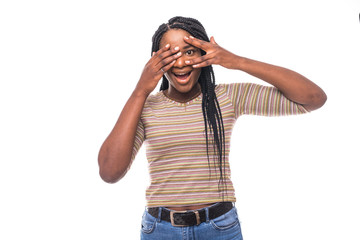 Closeup portrait of a young woman shy and flirting with hands covering entire face except one wide...