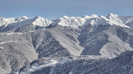 Panoramic view of the mountains and the village of Krasnaya Polyana. Aerial photography with copter. Esto-Sadok. Sochi. ski resort. Nature, snow, skiing, snowboarding.
