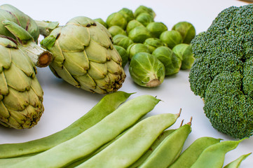 artichoke, beans, broccoli, Brussels sprouts, green vegetables on white background side view