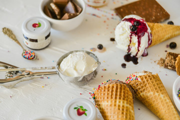 A Kit For Making Ice Cream: Spoon For Ice Cream, Ice Cream Cones, Jam, Topping, Chocolate, Sprinkles, Coconut Shavings. on white background. Concept Ideas For A Gift With Their Own Hands.