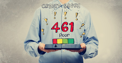 Poor credit score theme with young man holding a tablet computer