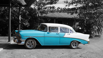 colorkey of baby blue cuban classic car in front of old cottage