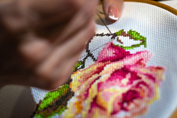 The process of working on a fragment of embroidery close-up, selective focus, hobby.