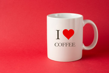 I love coffee words, inscription. White Cup with red heart. Red background with copy space.