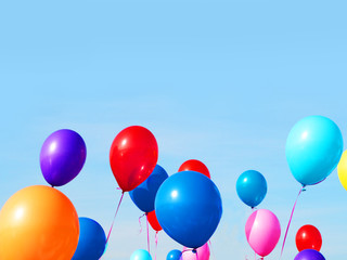 Multicolored inflatable balloons filled with helium against the blue sky. Concept of holiday,...