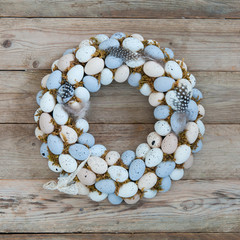 Delicate Easter wreath on the door of quail eggs on a wooden background. Close up