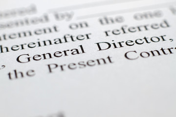 Fototapeta premium Fragment of a contract printed on paper. Macrophotography The words of the General Director captured close-up. The buyer and the seller made a contract on paper. Selective focus.