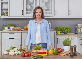 Cheerful vegetarian woman in the kitchen