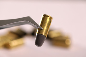 Obraz na płótnie Canvas Gun bullet holding with tweezer
