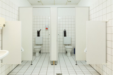 Zwei Toiletten nebeneinander mit geöffneter Türe