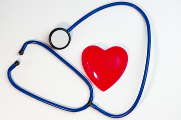 red heart and a stethoscope lying on a white background