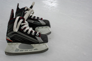 Kid’s Hockey skates lying over ice rink with copy space 