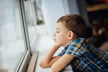 very cute and beautiful teenager sitting near a window.