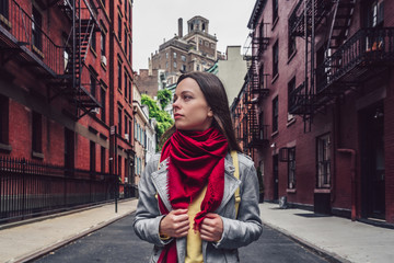 Fototapeta na wymiar Attractive girl with a red scarf on the street