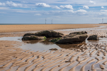 North Sea coast in Cambois, Northumberland, England, UK - the beach with wind turbines in the background