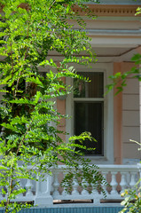 Old historic stone house on the yard with trees around. Old city buildings before and after restavration. Ancient windows, roofs, balconies. sculptures, walls  South, summer 