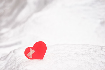 Red paper Valentine heart on snow. Valentine's day gift.