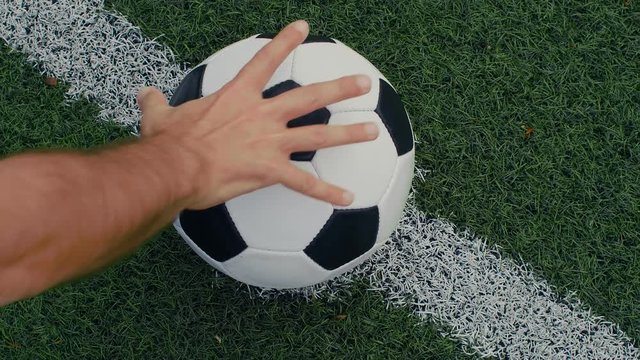 Soccer player puts a ball on the center point of a football field, 4k slow motion