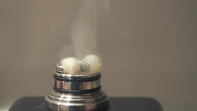 atomizer of a regenerable electronic cigarette in operation. Steaming by heating the resistance with the wadding soaked in liquid causes a cloud of vapor