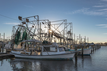 Shrimping boats at rest on empty docks as sun sets