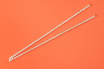 Chopsticks on peach background. Food theme composition