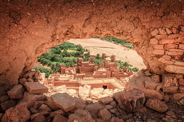 Popular point of view of the valley of the desolating river Onila through a hole in a wall of Ancient Kasbah in Ait-Ben-Haddou, Morocoo. Famous ancient berber kasbah. near Ouarzazate city in Morocco