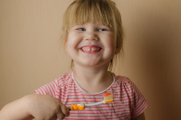 Happy little European girl brushing her teeth