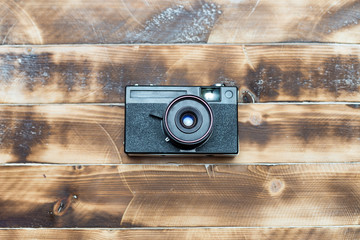Retro camera on wood table background, vintage color tone