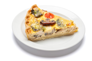 Slice of traditonal homemade spinach chicken quiche tart or pie on plate