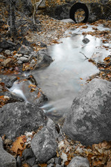 view through water tunnel tube in fall scenery in forest with flowing river in long exposure 