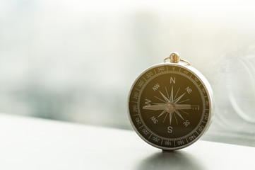 Single manual compass and light flare with blur city background.