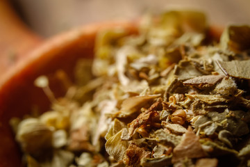 Dried oregano spice in a spoon. Extreme macro photography.