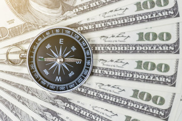 Dollar banknotes with compass, money and financial marketing direction conception.  Business strategy direction to make money.