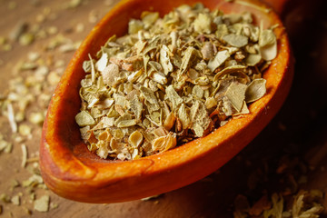 Dried oregano spice in a spoon. Extreme macro photography.