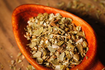 Dried oregano spice in a spoon. Extreme macro photography.