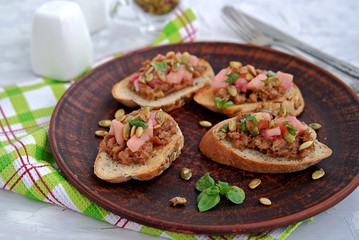 Bruschetta with duck confit pate, apple chutney and caramelized pumpkin seeds. Selective focus.