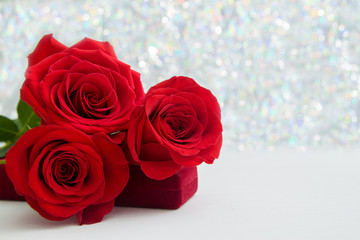 Three Red Roses and jewelery present box with boke Background. copy space - Valentines and 8 March Mother Women's Day concept.