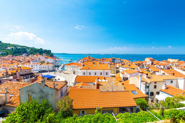 Aerial panorama view of Piran city, Slovenia. Look from tower in church. In foreground are small...