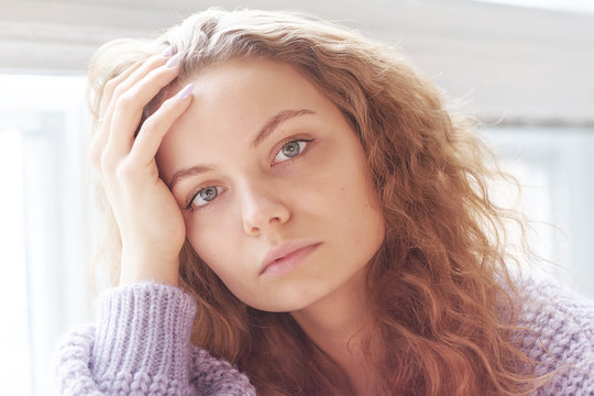 Depressed young woman near window at home, closeup - Image