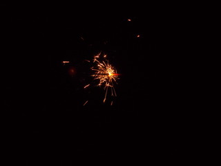 Fototapeta premium Sparklers in the dark. A sheaf of bright sparks and fire.