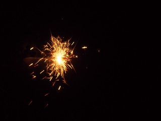 Fototapeta premium Sparklers in the dark. A sheaf of bright sparks and fire.