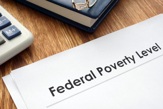 Federal Poverty Level FPL documents on a desk.