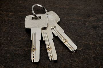 Key ring with keys over wooden background. Rent, buy home