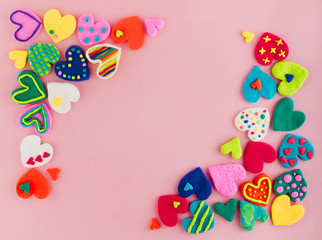 Colorful handmade plasticine hearts on pink background