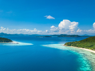 Aerial view of tropical island Bulalacao. Beautiful tropical island with white sandy beach, palm trees and green hills. Travel tropical concept. Palawan, Philippines
