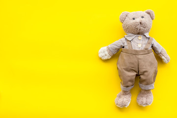 Craft toys for kids. Handmade teddy bear. Yellow background top view mock up