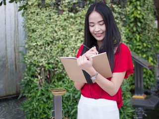 Young Asian female student with notebooks in her hands.A portrait of an Asian college student.education and learning concept.