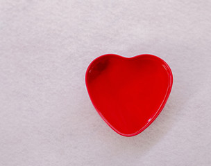 Red heart shape on a white paper background